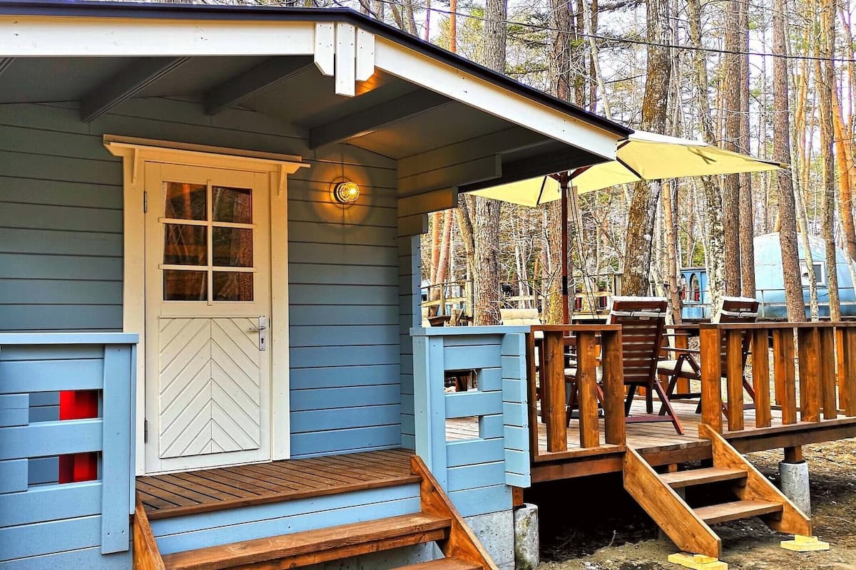 Eine kleine Holzhütte mit einer Holzterrasse und einem überdachten Veranda.