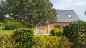 Una casa con techo inclinado, una ventana pequeña y una puerta.