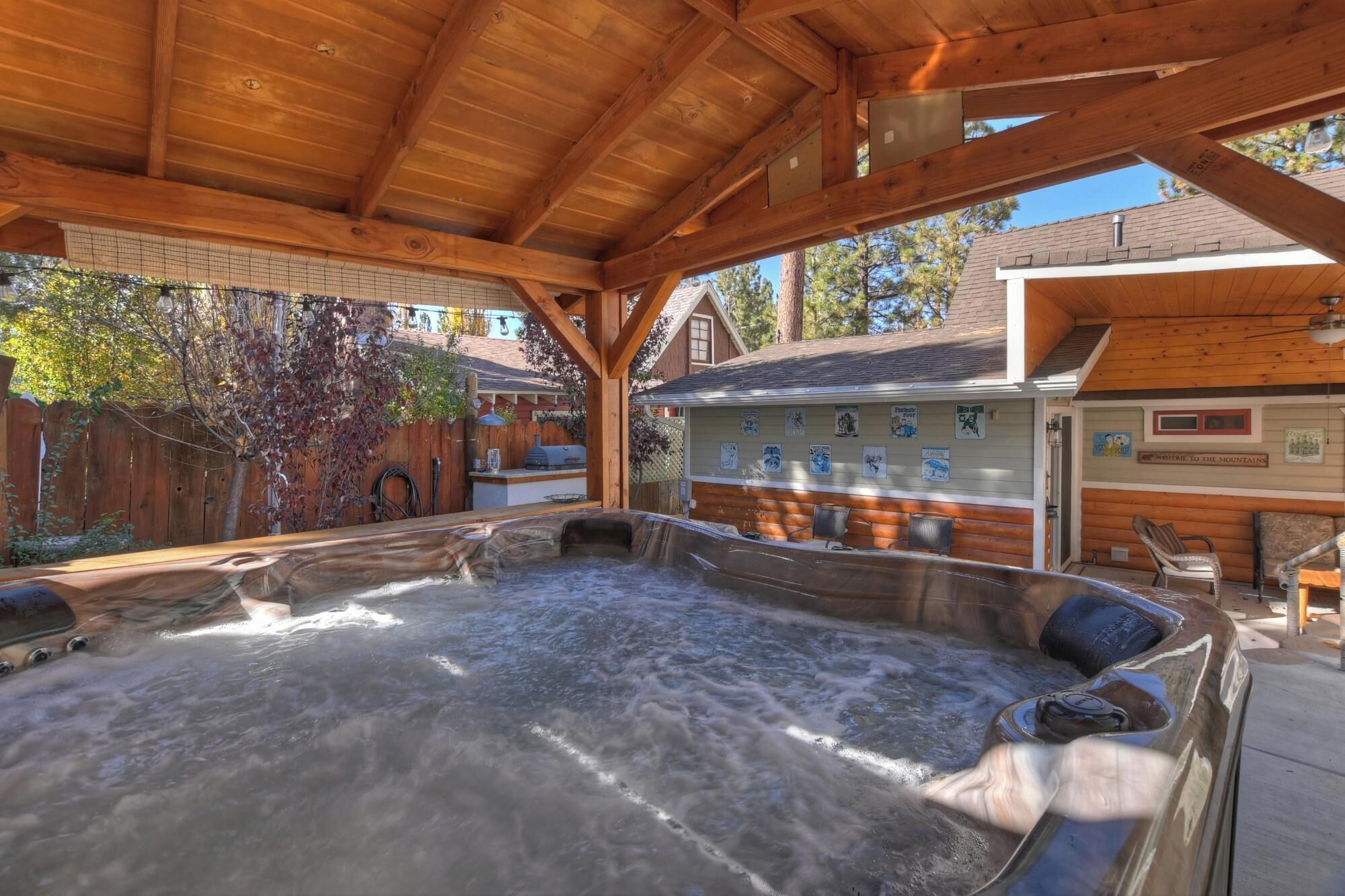 Une terrasse en bois avec un jacuzzi, des murs en bois et un panneau indiquant une vue sur la montagne.