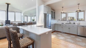 A spacious kitchen with a central island, stainless steel appliances, and a large window providing natural light. - Wonderful Views of Dillon Beach and Bodega Bay (Dillon Beach)