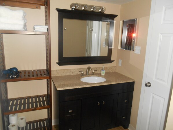 A bathroom with a sink, mirror, and shelves with towels. - Spectacular Seven Springs Skiing and golfing in Pennsylvania (Champion)