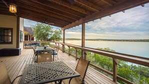 Eine Holzterrasse mit Gartenmöbeln mit Blick auf einen stillen See.