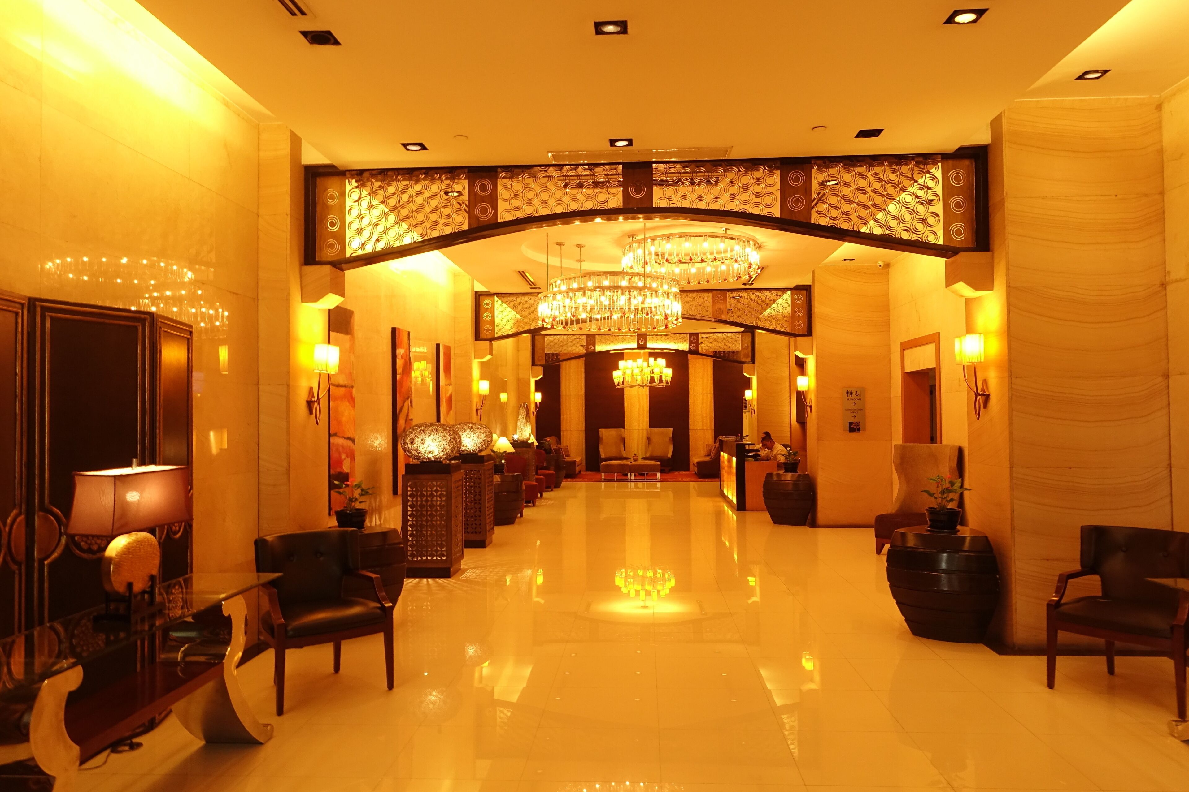 A spacious lobby with a polished floor, a reception desk, and seating areas.