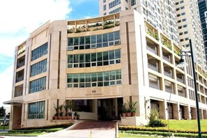 Hotel features a modern architectural design with large windows and well-manicured grounds.