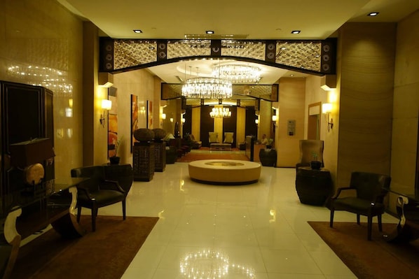 Experience the elegant lobby, featuring a circular seating area, decorative panels, and comfortable sofas and armchairs.