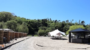 A campsite with tents, a small structure, and a dirt path. - Kibotcha - Hostel (Higashimatsushima)