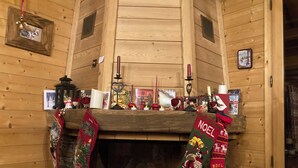 Un intérieur en bois agrémenté d’une cheminée, de décorations de Noël et de diverses décorations de fêtes.