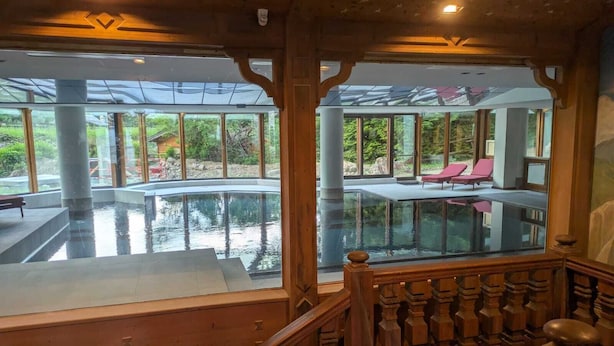 A pool area with clear glass walls, wooden railings, and a view of the outdoors. - Appart cozy 4/6 pers in residence hotel 4 *, TB located, calm, wifi, park (Chamonix-Mont-Blanc)