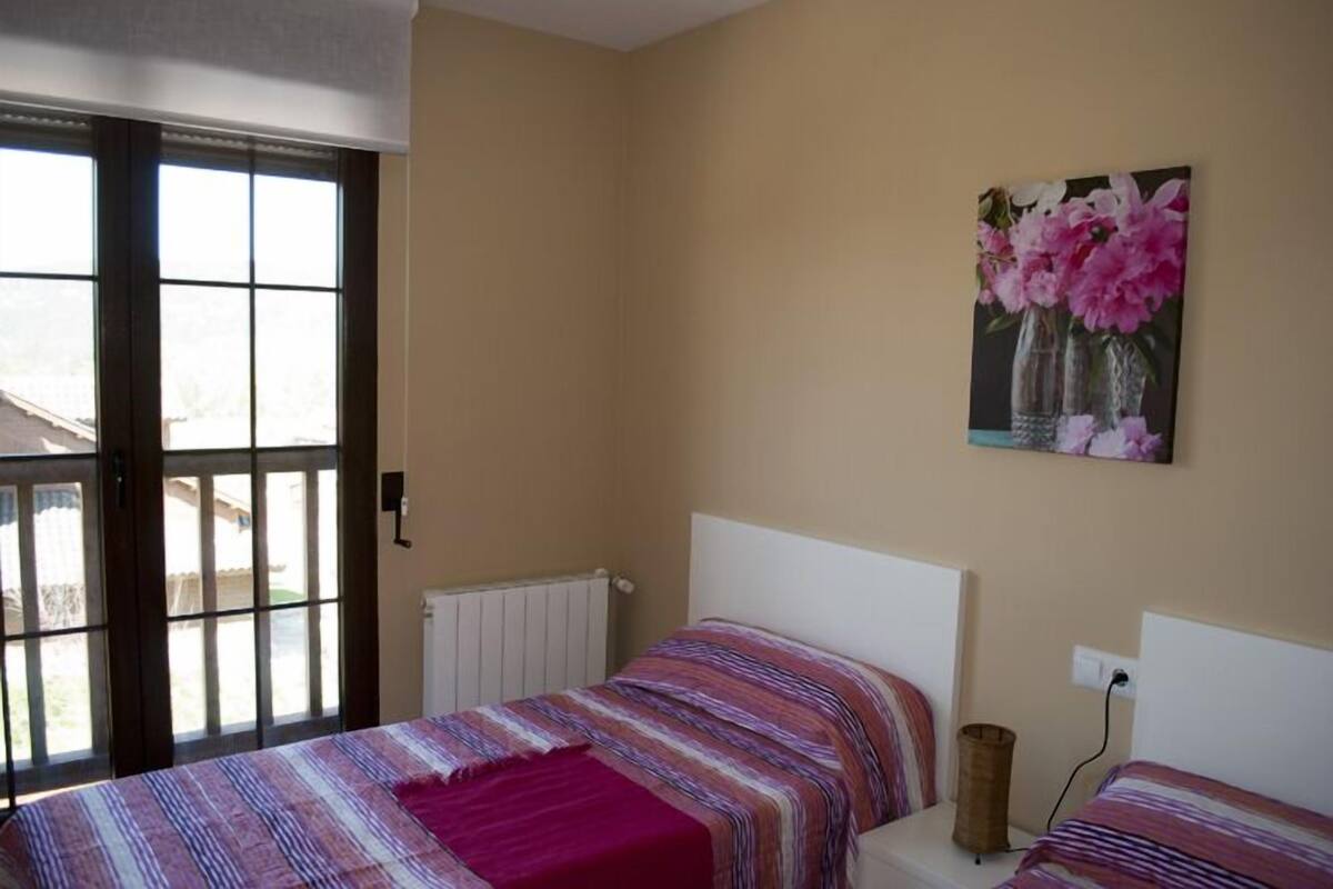 Une chambre à coucher avec un lit, une fenêtre et un tableau accroché au mur.