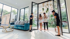 A modern interior with a blue sofa, a glass door, and a view of the outside. - Popular Hotel & Spa (Siem Reap)