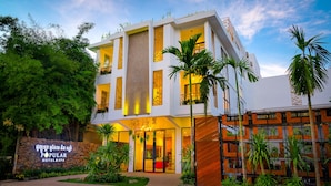 A modern hotel with a stone facade, large windows, and a well-lit entrance. - Popular Hotel & Spa (Siem Reap)