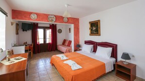 A hotel room with a large bed, a desk, a chair, and a small table. - Angelina Studios (Skiathos)