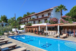Un hôtel doté d’une piscine, d’un espace extérieur aménagé et d’un bar.