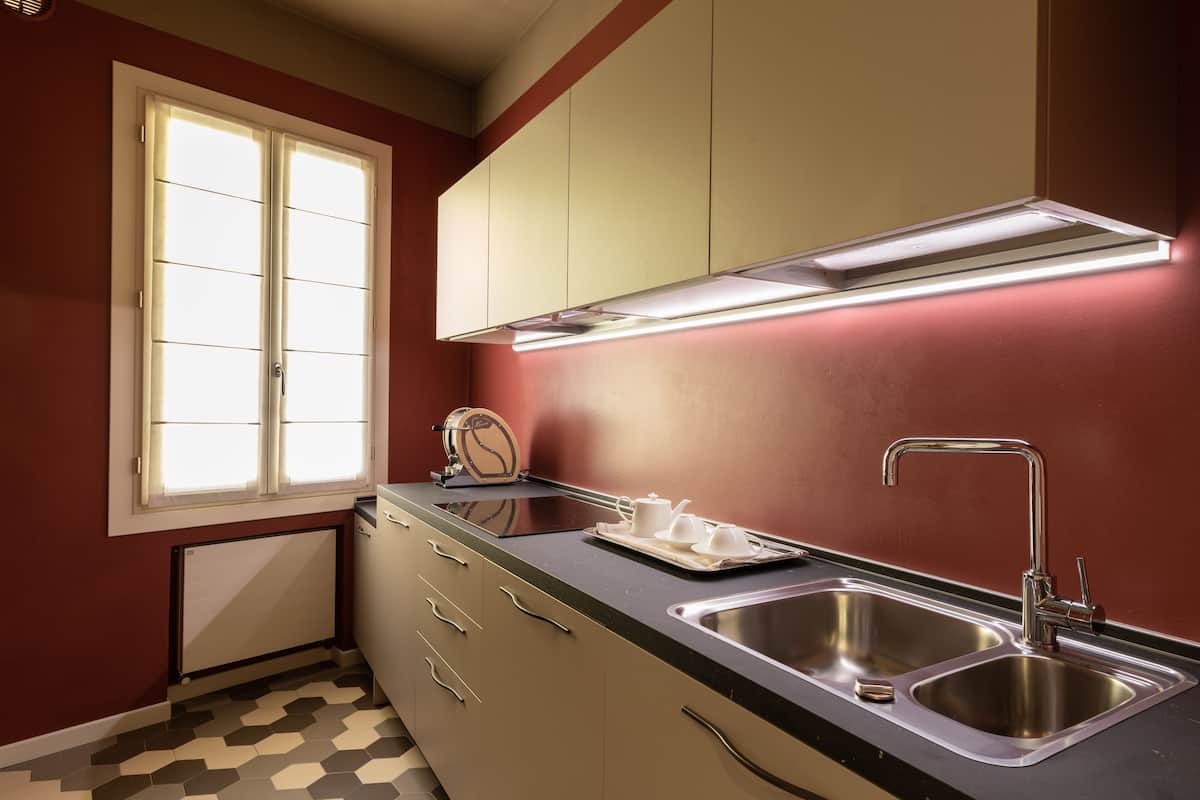 A kitchen with a double sink, a window, and a radiator.