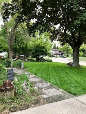 Welcome to a serene residential haven with a beautifully maintained garden and an entrance.
