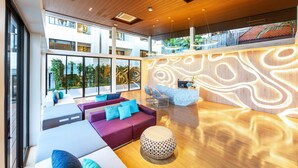 A modern hotel lobby with a wooden ceiling, large windows, a reception desk, and seating areas. - LIV Hotel Phuket Patong Beachfront (Patong)