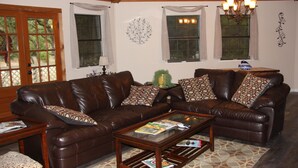 A living room with two brown leather sofas, a glass coffee table, and a patterned rug. - Canyon Lake Texas Hill Country (Canyon Lake)