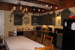 Une cuisine avec des meubles en bois, une table à manger et un lustre.