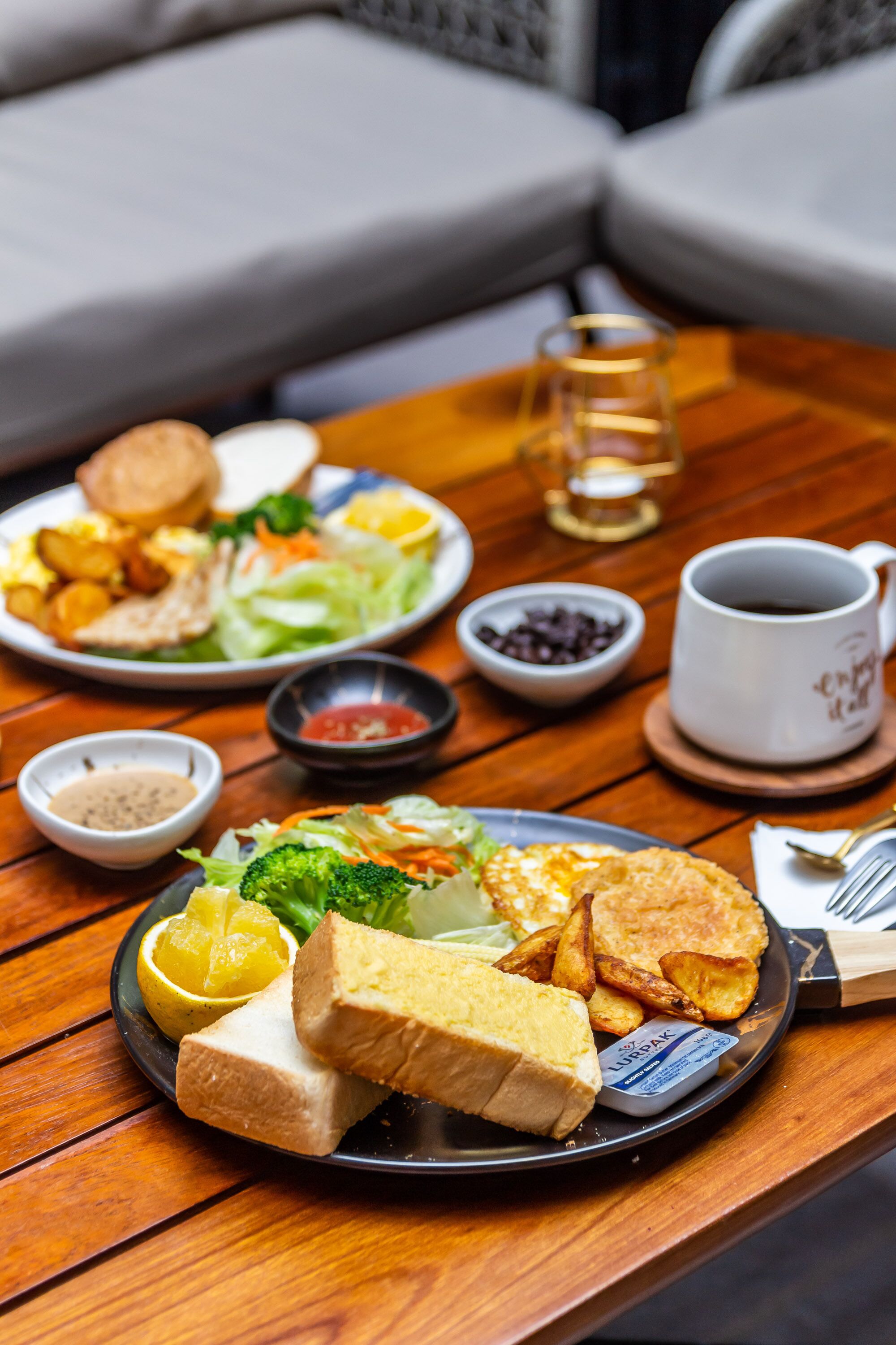 A dining table with a variety of dishes including bread, potatoes, and salad.