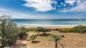 A coastal view with a beach, trees, and a clear sky. - Kenting seawall Inn 112 (Hengchun)
