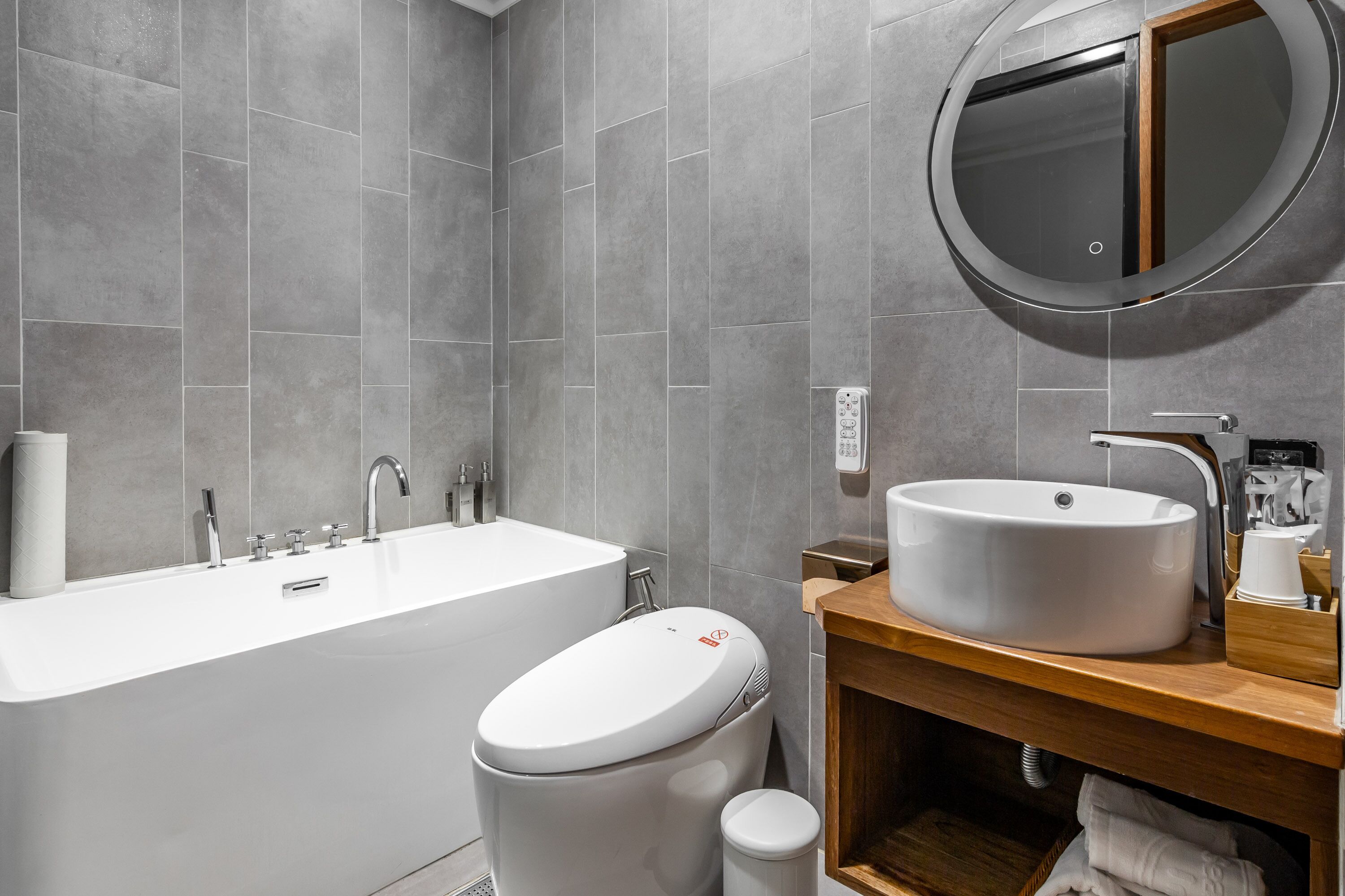 A modern bathroom with a bathtub, toilet, and sink.