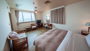 A hotel room with a bed, a desk, a chair, a television, and a window with curtains. - JiaHua Hotel (Magong)