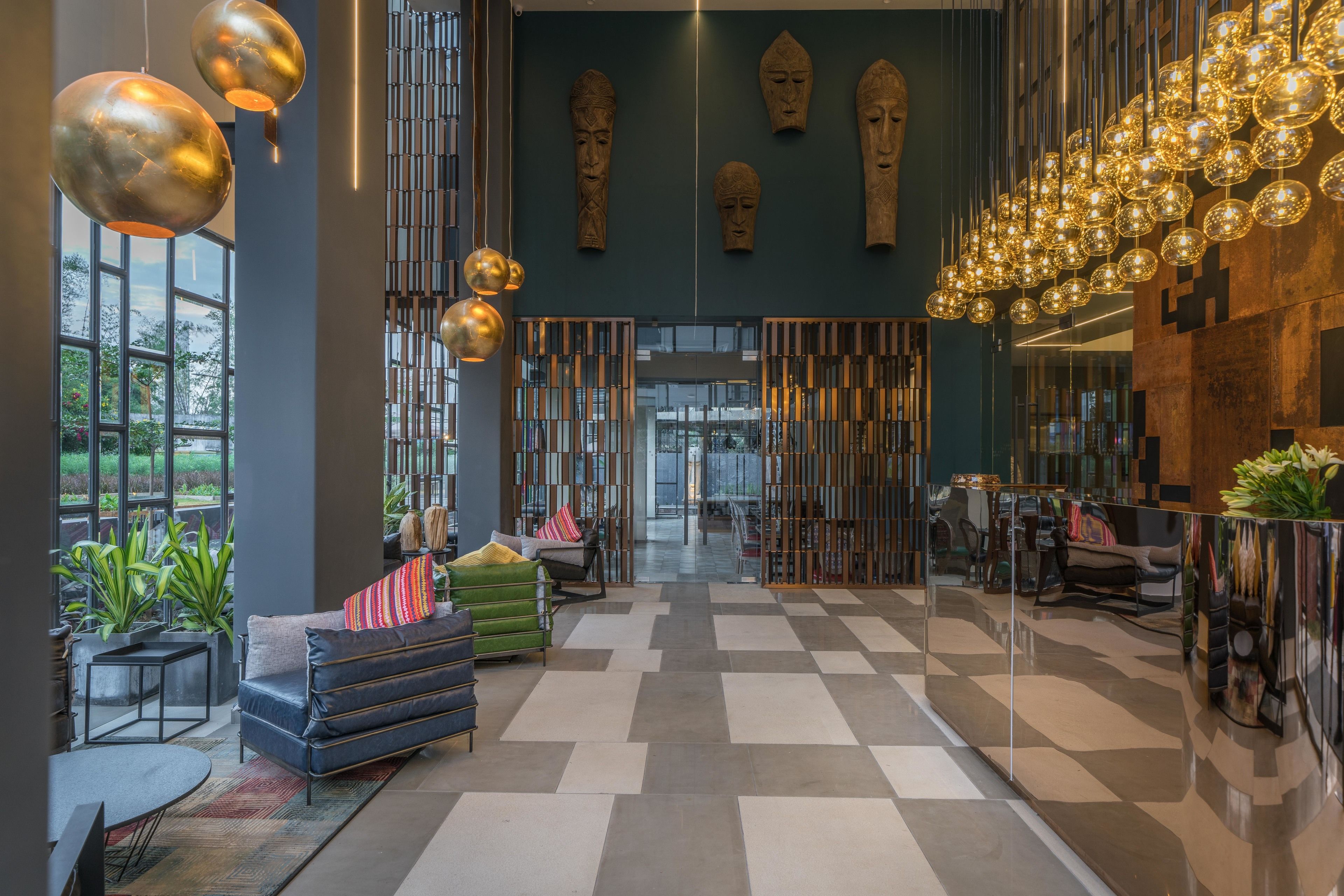 A modern lobby with a checkered floor, seating areas, and decorative lighting.