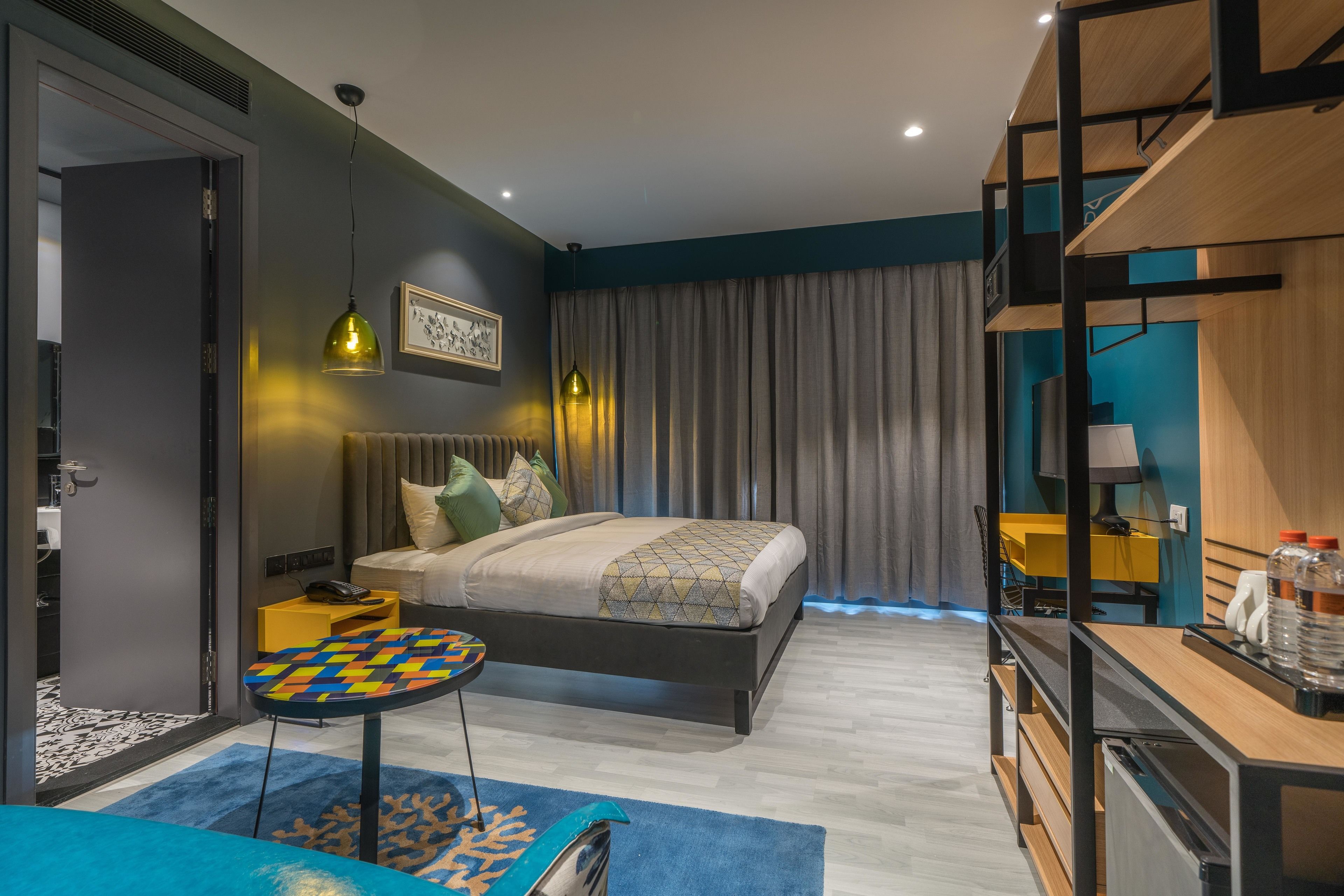 A modern bedroom with a bed, bedside table, and a desk area.