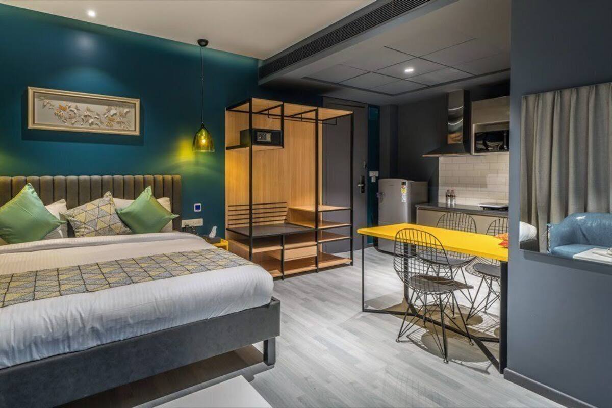 A modern bedroom with a bed, bedside table, and a desk with chairs.