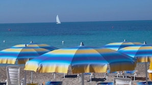 Una platja amb nombrosos paraigües i cadiretes de platja.