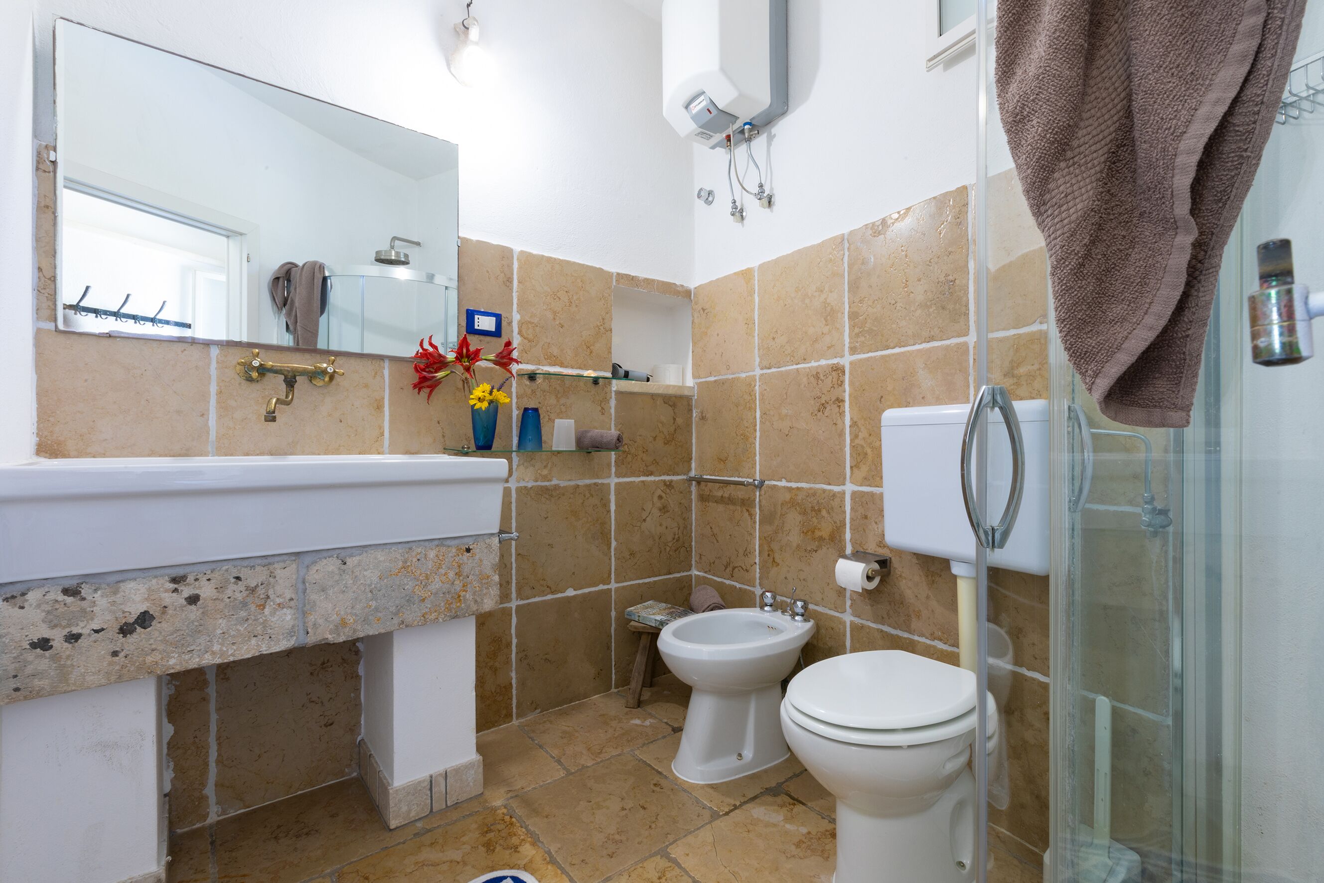 Une salle de bain équipée d’un lavabo, d’un bidet, de toilettes et d’une douche à parois en verre.