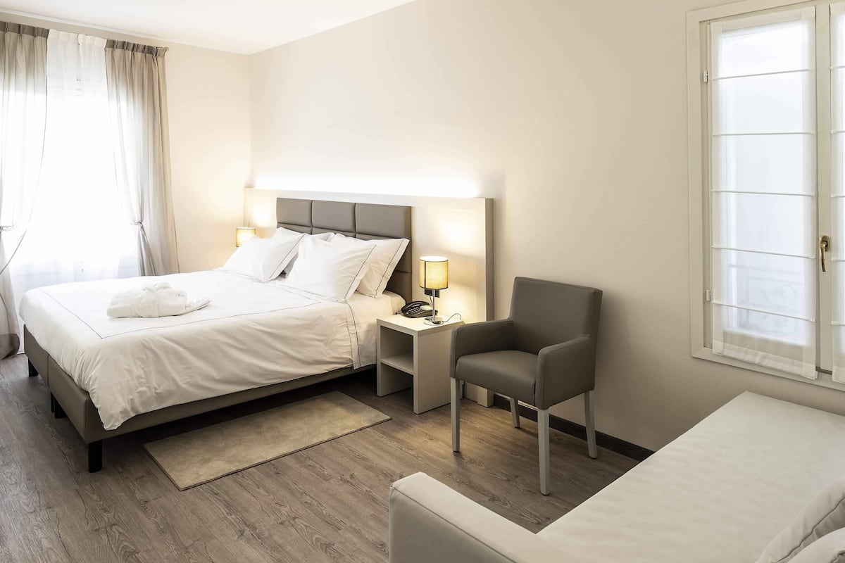 Junior Quadruple Room, Garden View | Minibar, in-room safe, desk, soundproofing