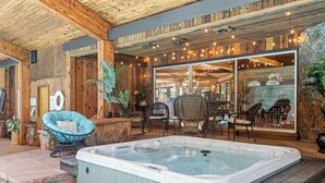 A hot tub in a wooden cabin with wicker chairs and a stone fireplace. - Panorama - Your Private Resort by Estes Park Homes (Estes Park)