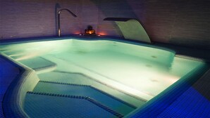 A hot tub with a tiled floor and a small statue in the center. - Halex Room & Food (Nettuno)