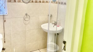 A bathroom with a toilet, sink, and shower area. - Beautiful Apartment in Century City (Cape Town)