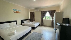 Una camera d'albergo con due letti, una scrivania, una televisione e una finestra con tende.
