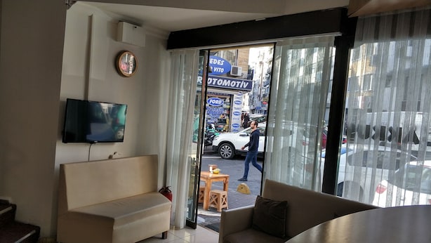 A living room with a sofa, a television, and a window with curtains. - Akkus Hotel (Istanbul)