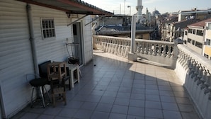 A rooftop terrace with tiled flooring, a small table, and a chair. - Akkus Hotel (Istanbul)