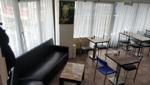 A dining area with a black sofa, multiple tables, and chairs. - Akkus Hotel (Istanbul)