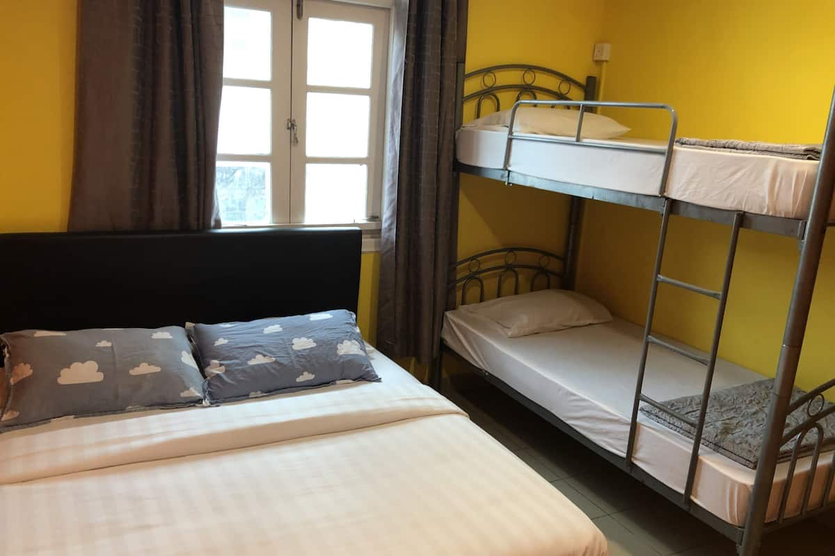 A bunk bed room with a single bed and a window.