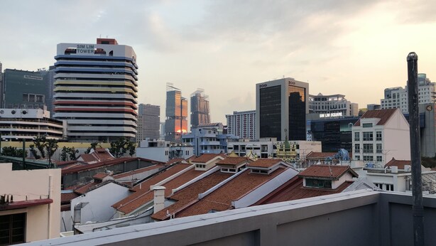 Un paisaje urbano con edificios modernos y tradicionales, incluyendo la TORRE SIM LIM y la PLAZA SIM LIM.