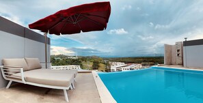 Una piscina al aire libre, sillones reclinables de piscina