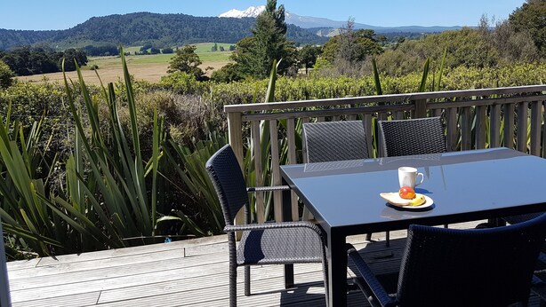 Una terrazza con tavolo e sedie che si affaccia su un paesaggio montano.