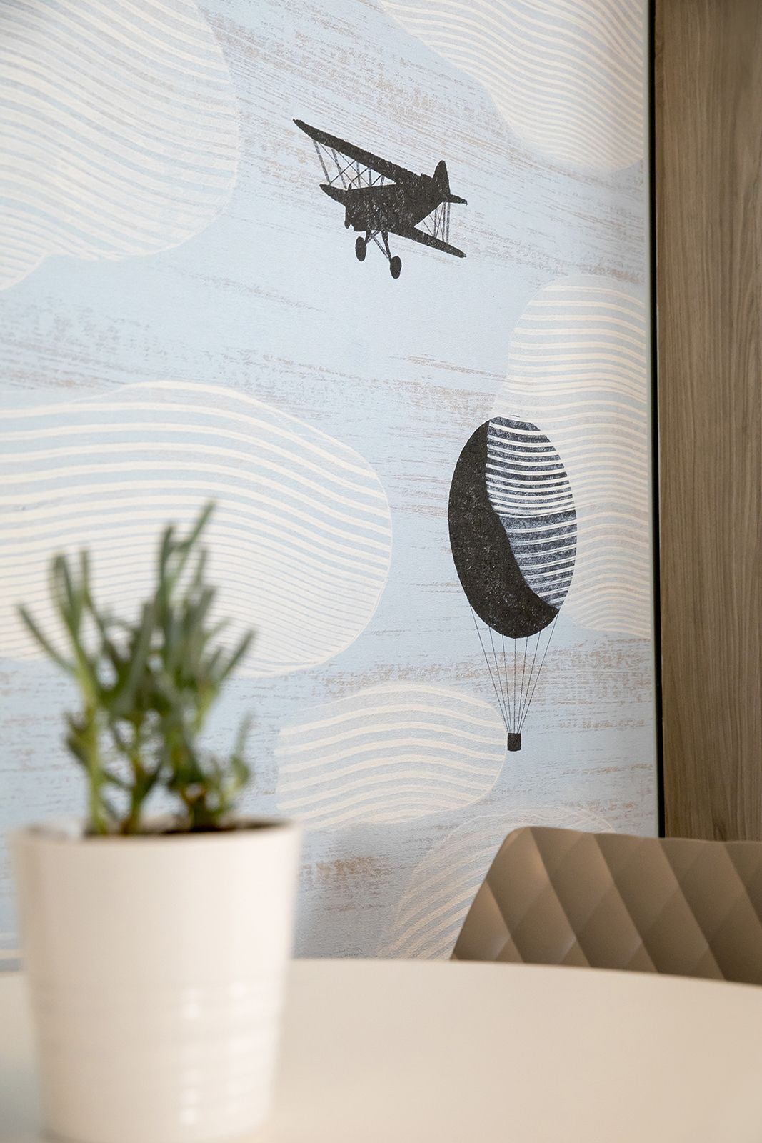 A wall with a vintage airplane and a balloon illustration.