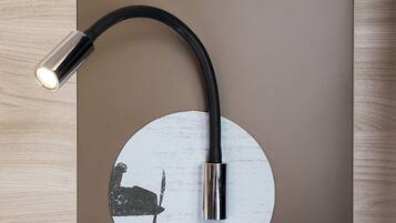 A wall-mounted light fixture with a curved design and a circular element.