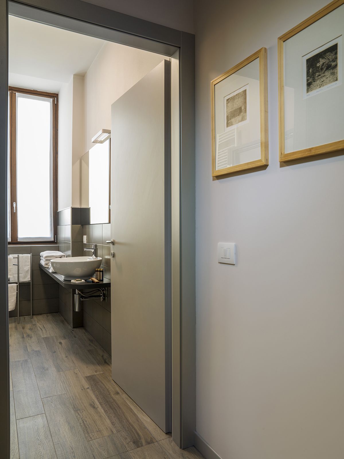 Een moderne badkamer met een groot wastafel, spiegel en handdoekhouder.