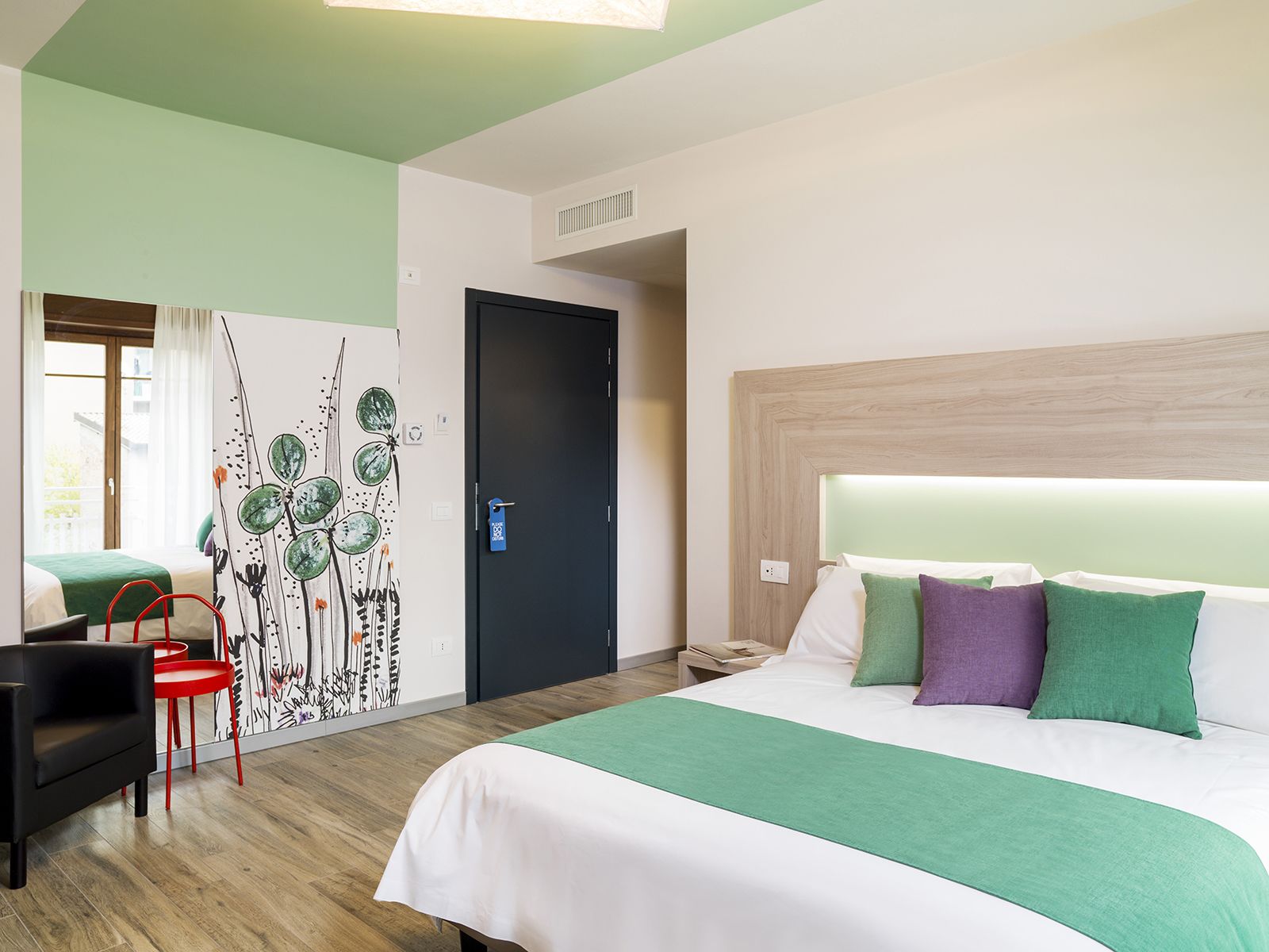 Een hotelkamer met een bed, een bureau en een stoel.
