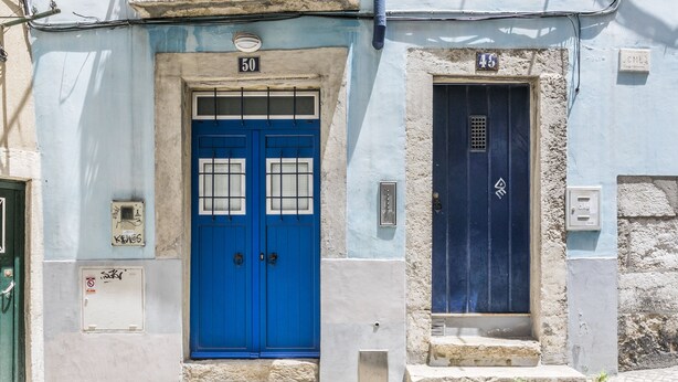 A building with a blue door marked with the number 50 and a smaller door marked with the number 45. - LxWay Apartments Graça - Santa Marinha (Lisbon)