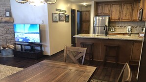 A modern kitchen with wooden cabinets, a stainless steel refrigerator, and a built-in island with bar stools. - Giant Step 3 Condo!  Ski-in/Ski-Out. Completely Remodeled!  WI-FI (Brian Head)