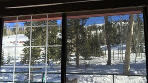 A window with a view of a snowy landscape with trees and a clear blue sky. - Giant Step 3 Condo!  Ski-in/Ski-Out. Completely Remodeled!  WI-FI (Brian Head)